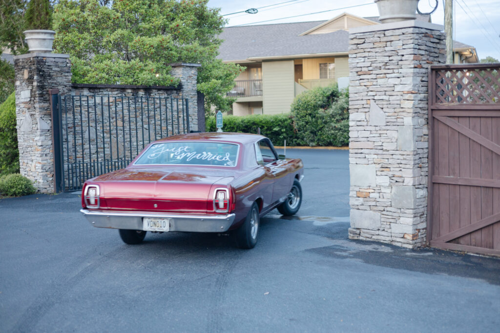 Taylor and Alex driving away from their Park Crest wedding in Alex’s red car