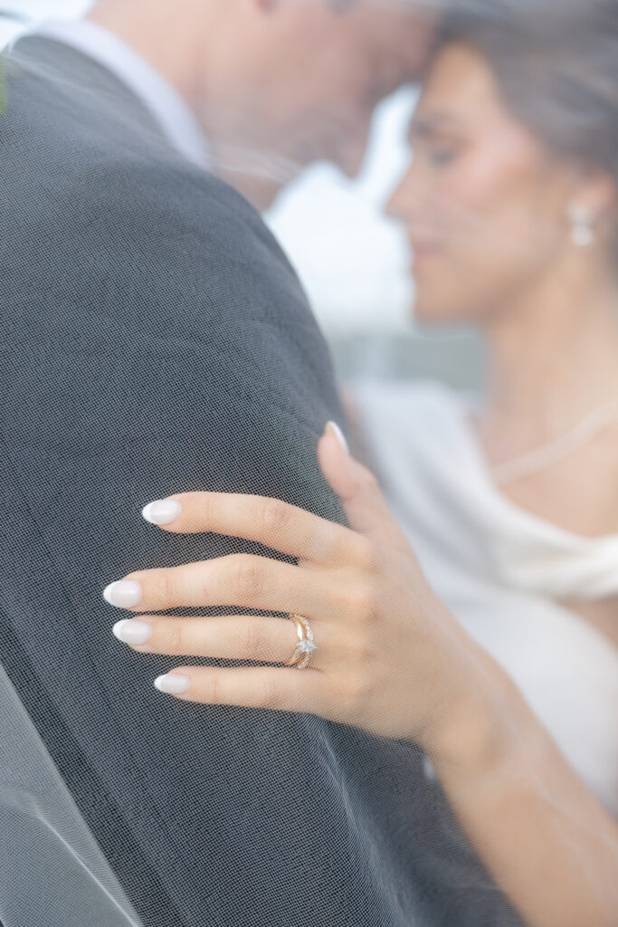 Brooke and Zach underneath her long wedding veil at Old Overton Country Club