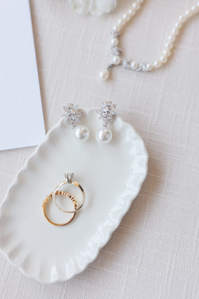 Pearl bridal jewelry styled with wedding rings