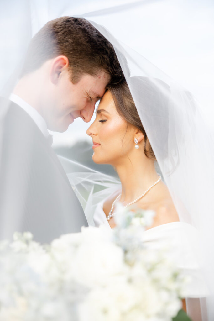 Brooke and Zach underneath her long wedding veil at Old Overton Country Club